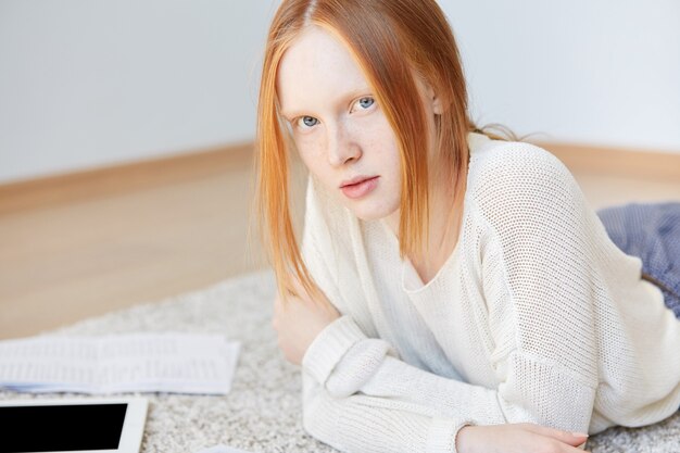 Portret van het jonge roodharige vrouw stellen