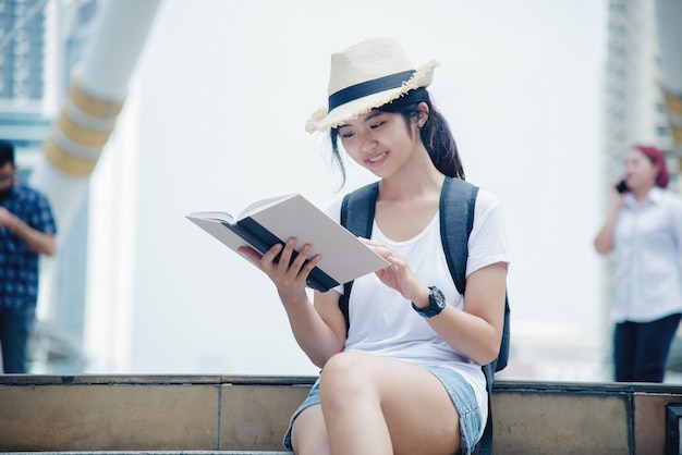 Portret van het jonge studentenmeisje glimlachen die en op laptop computer werken leren