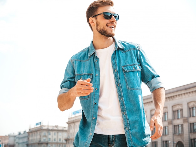 Portret van het knappe het glimlachen modieuze model van hipster lumbersexual zakenman. De mens kleedde zich in de kleren van het jeansjasje.