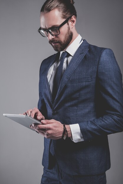 Portret van het knappe model van de manierzakenman gekleed in elegant blauw kostuum met glazen