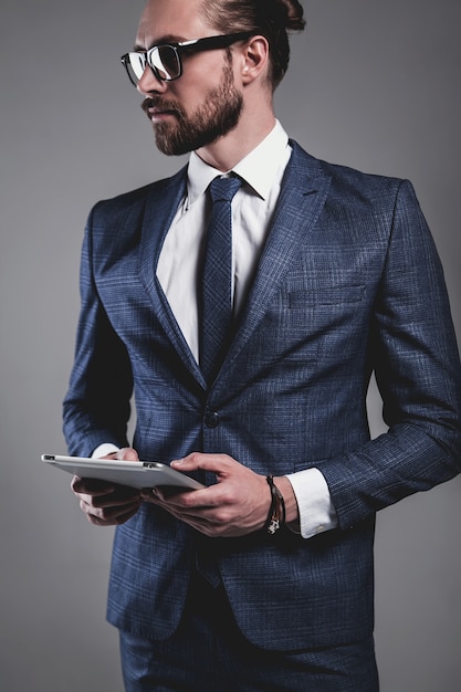 Portret van het knappe model van de manierzakenman gekleed in elegant blauw kostuum met glazen