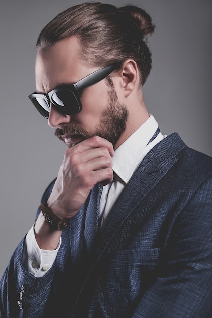 Portret van het knappe model van de manierzakenman gekleed in elegant blauw kostuum met glazen