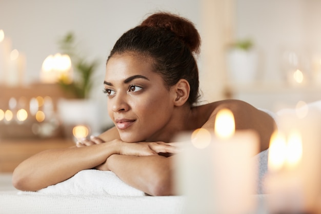 Portret van het mooie Afrikaanse vrouw rusten die in kuuroordsalon ontspannen.