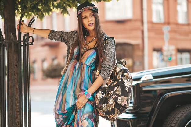 Portret van het mooie model van de glamour donkerbruine tiener in de zomer hipster kleren en zak. Meisje poseren in de straat. Vrouw in cap