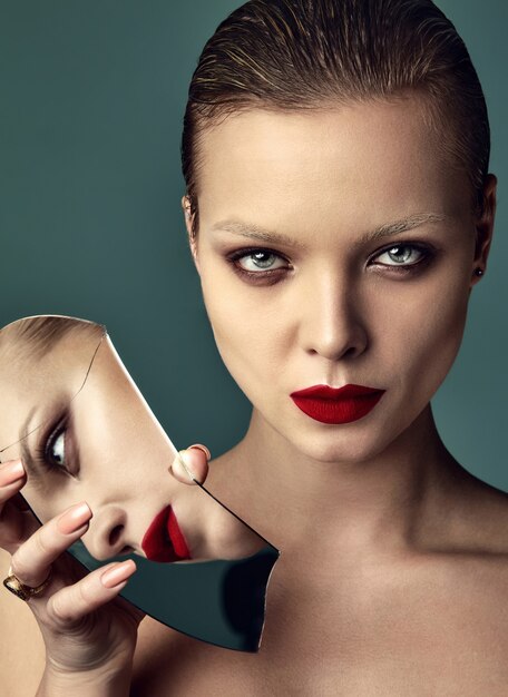 Portret van het mooie model van de manier modieuze donkerbruine vrouw met avondmake-up en rode lippen in wit jasje