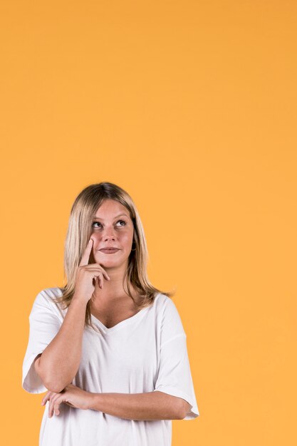 Portret van het overwegen van jonge vrouw die omhoog kijkt