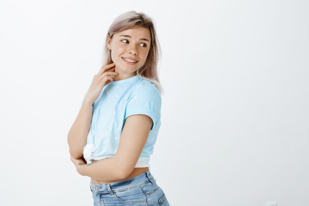 Portret van het positieve blond meisje poseren in de studio