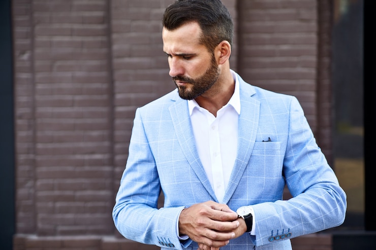 Gratis Foto portret van het sexy knappe model van de manierzakenman gekleed in het elegante blauwe kostuum stellen op straatachtergrond. metrosexual