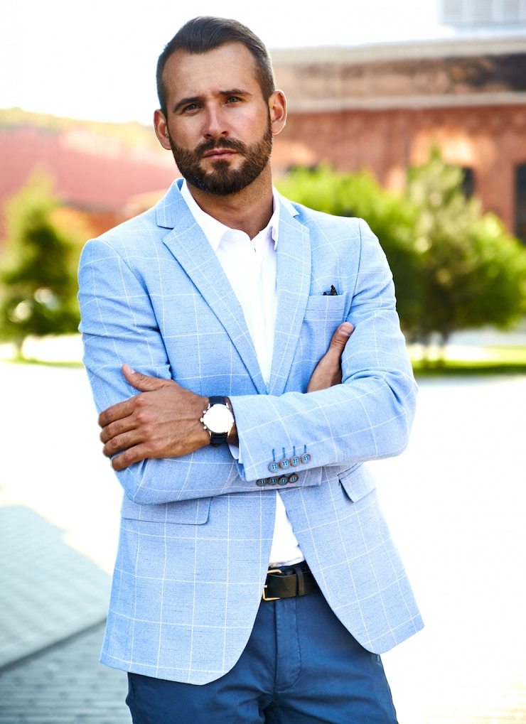 Gratis Foto portret van het sexy knappe model van de manierzakenman gekleed in het elegante blauwe kostuum stellen op straatachtergrond. metrosexual