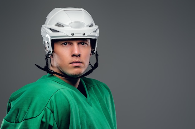 Portret van hockeyspeler geïsoleerd op een grijze achtergrond.