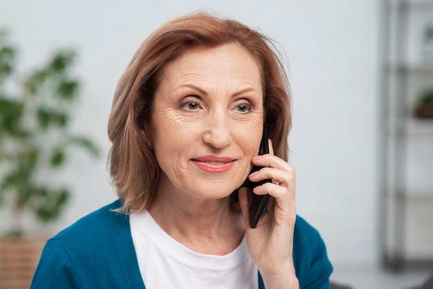 Portret van hogere vrouw die op de telefoon spreekt