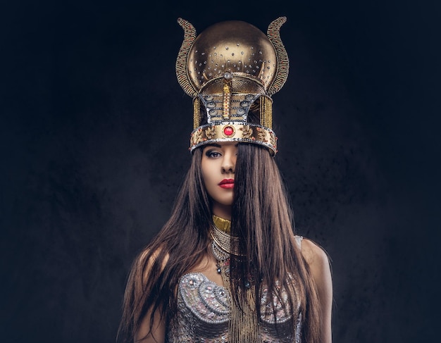Portret van hooghartige egyptische koningin in een oud faraokostuum. geïsoleerd op een donkere achtergrond.