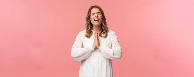 Portret van hoopvolle wanhopige jonge mooie blonde vrouw in witte jurk zeuren klagen wrede leven bidden god laat droom uitkomen huilen hart uit tijdens smeken vraag alsjeblieft