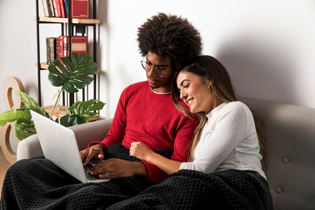 Portret van interracial paar met behulp van laptop samen