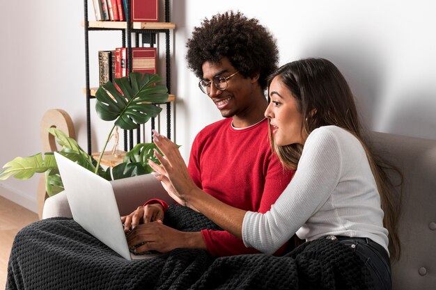 Portret van interracial paar met behulp van laptop samen