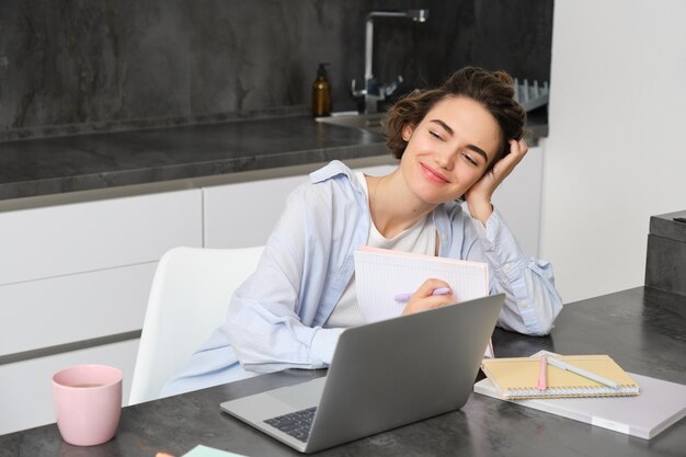 Portret van jaren vrouw studeert online kijkt cursus in internet werkt op laptop vanuit haar huis