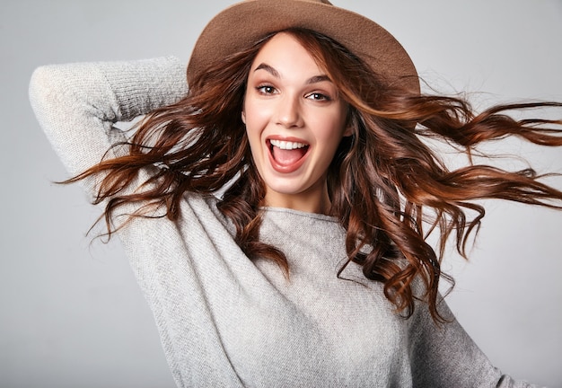 Gratis foto portret van jong modieus het lachen model in grijze toevallige de zomerkleren in bruine hoed met natuurlijke make-up