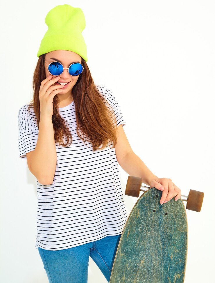 Gratis Foto portret van jong modieus vrouwenmodel in toevallige de zomerkleren in het gele beaniehoed stellen met longboardbureau. geïsoleerd op wit