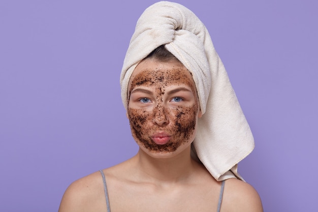 Portret van jonge aantrekkelijke vrouw met witte handdoek op haar hoofd, poseren