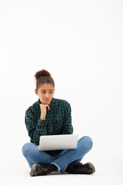 Portret van jonge Afrikaanse vrouw met laptop op wit