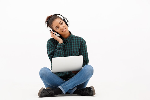 Portret van jonge afrikaanse vrouw met laptop op wit