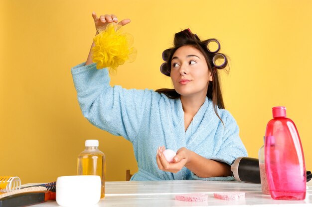 Portret van jonge blanke vrouw in haar schoonheidsdag, huid en haarverzorgingsroutine. Vrouwelijk model met natuurlijke cosmetica room en oliën toe te passen voor make-up. Lichaams- en gezichtsverzorging, natuurlijk schoonheidsconcept.