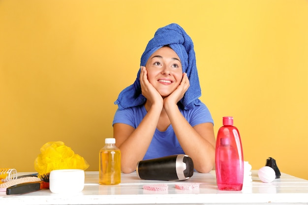 Portret van jonge blanke vrouw in haar schoonheidsdag, huid en haarverzorgingsroutine. Vrouwelijk model met natuurlijke cosmetica room en oliën voor make-up toe te passen. Lichaams- en gezichtsverzorging, natuurlijk schoonheidsconcept.