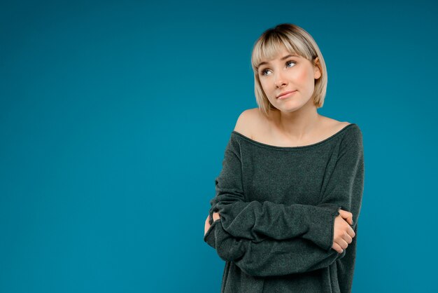 Portret van jonge blonde mooie vrouw over blauw muurexemplaar