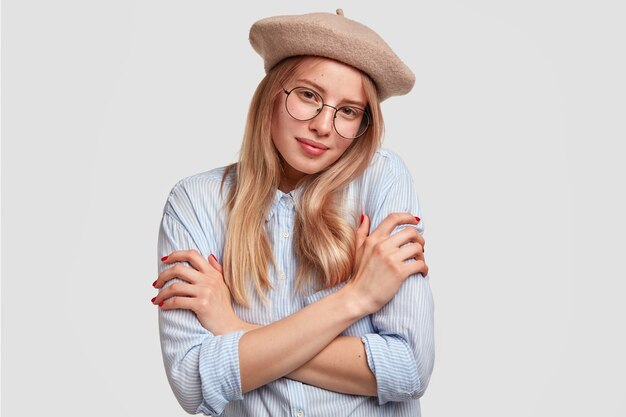 Portret van jonge blonde vrouw die baret draagt