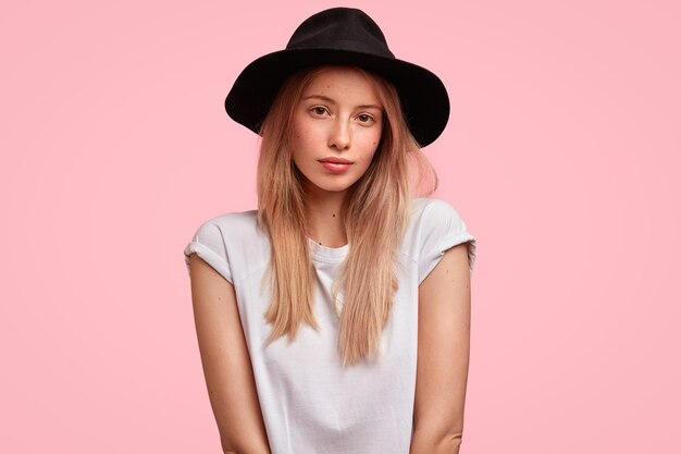 Portret van jonge blonde vrouw die grote hoed draagt