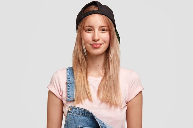 Portret van jonge blonde vrouw in denim overall