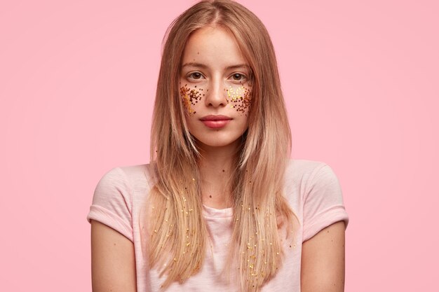 Portret van jonge blonde vrouw met glitters op gezicht