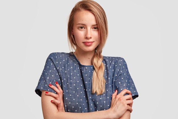 Portret van jonge blonde vrouw met vlecht en polka dot blouse