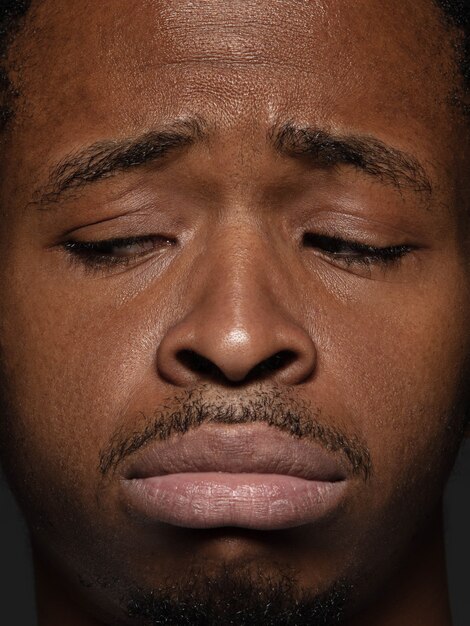 Portret van jonge en emotionele Afro-Amerikaanse man close-up. mannelijk model met verzorgde huid en gezichtsuitdrukking. Concept van menselijke emoties. Boos, verdrietig, gedemotiveerd.