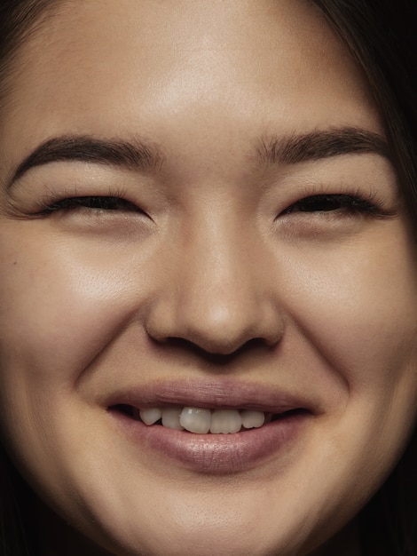 Gratis foto portret van jonge en emotionele chinese vrouw close-up. zeer gedetailleerde fotoshoot van een vrouwelijk model met een goed onderhouden huid en een heldere gezichtsuitdrukking. concept van menselijke emoties. glimlachen naar de camera.