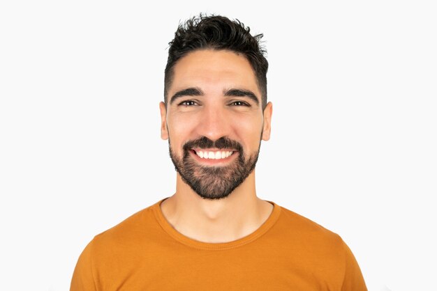 Portret van jonge gelukkig man glimlachend tegen witte ruimte
