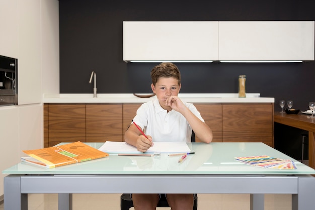 Portret van jonge jongen die zijn huiswerk doet