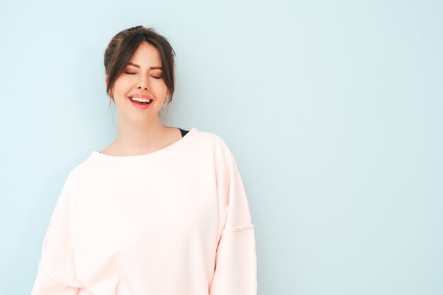 Portret van jonge mooie glimlachende vrouw in trendy roze zomerkleding