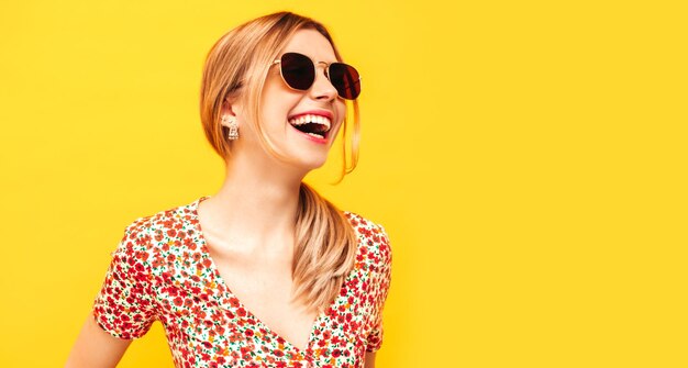 Portret van jonge mooie lachende blonde vrouw in trendy zomerkleren zorgeloze vrouw poseren in de buurt van gele muur in studio Positief model plezier binnenshuis vrolijk en gelukkig