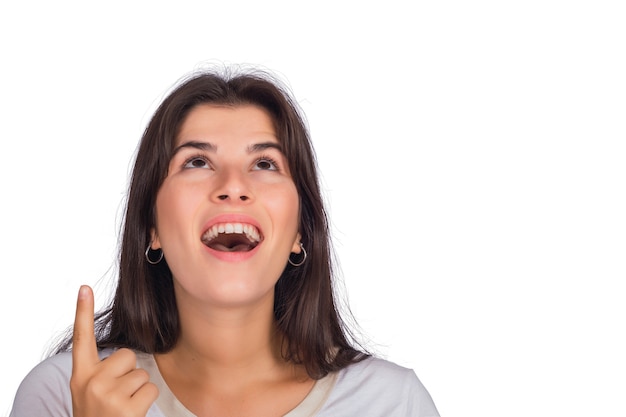 Portret van jonge mooie vrouw die en iets in studio tonen wijst.