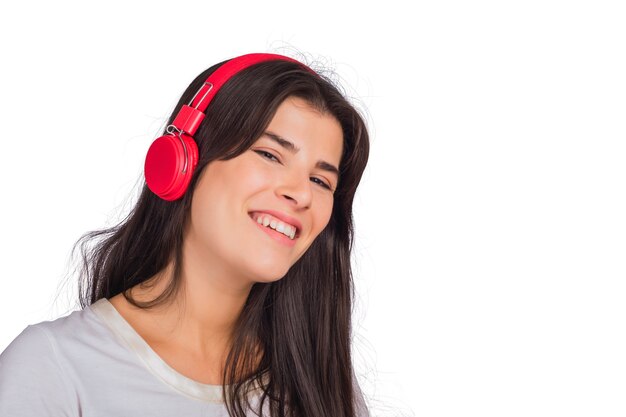 Portret van jonge mooie vrouw, luisteren naar muziek met rode koptelefoon op studio.