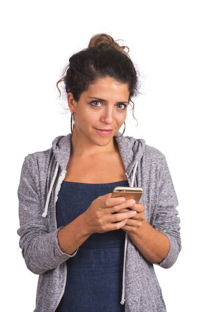 Portret van jonge mooie vrouw met behulp van haar mobiele telefoon in de studio. Geïsoleerde witte achtergrond. Technologie en communicatieconcept.