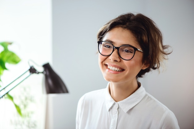 Portret van jonge mooie zakenvrouw glimlachend op werkplek op kantoor.