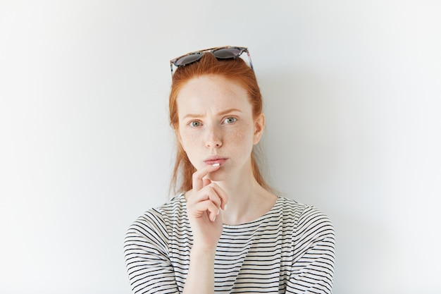 Gratis foto portret van jonge roodharige vrouw die zonnebril draagt