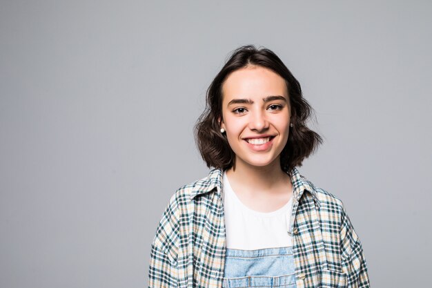 Portret van jonge vrolijke mooi meisje met donker lang haar in casual grijs shirt glimlachend met tanden, op zoek close-up