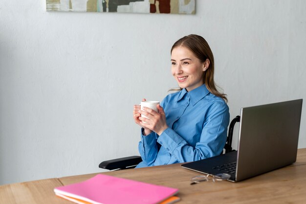 Portret van jonge vrouw die van een kop van koffie geniet