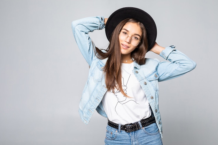 Gratis Foto portret van jonge vrouw in zwarte slappe hoed dat op witte muur wordt geïsoleerd