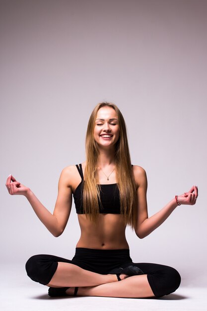 Portret van jonge vrouw mediteren in pose van lotus geïsoleerd