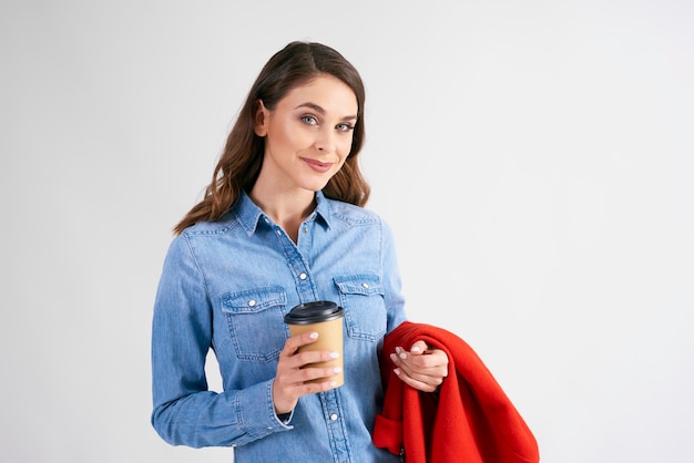 Portret van jonge vrouw met wegwerp kopje koffie