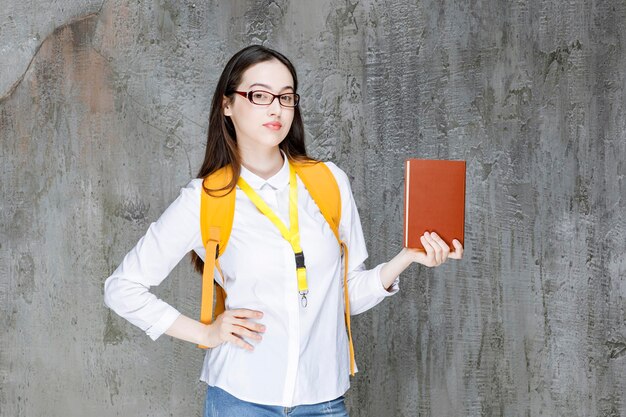 Portret van jonge vrouwelijke student in glazen die zich met boek bevinden. Hoge kwaliteit foto